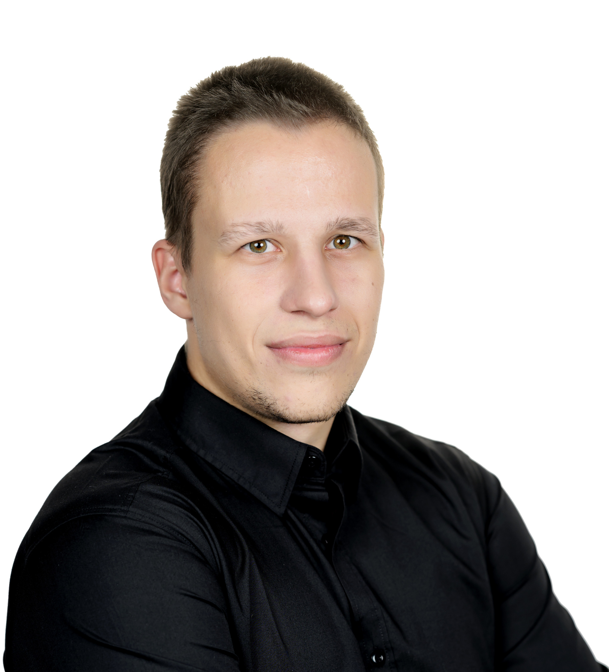 Man with short brown hair wearing a black shirt, arms crossed, looking at the camera against a white background.