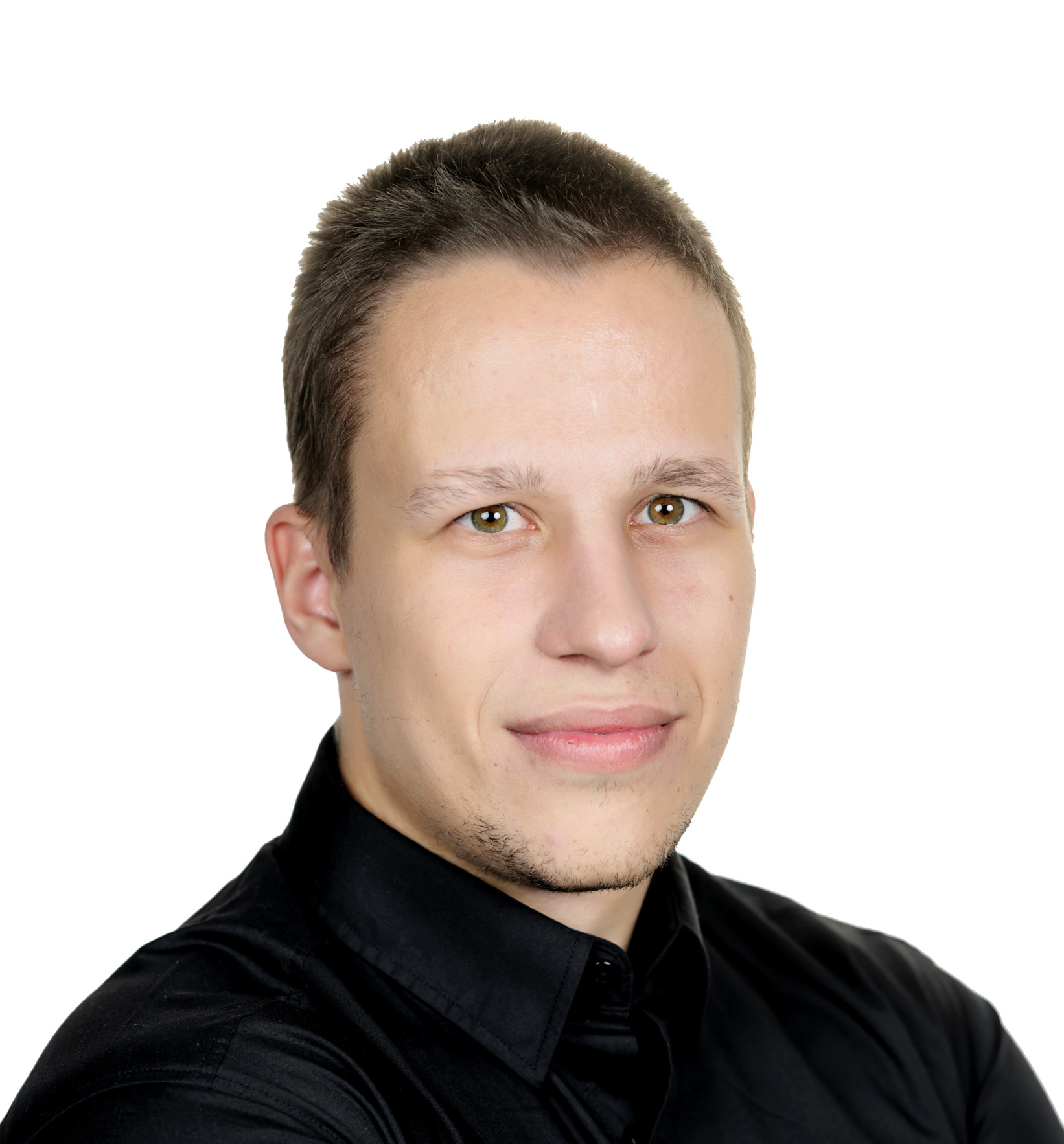Man with short brown hair wearing a black shirt, arms crossed, looking at the camera against a white background.