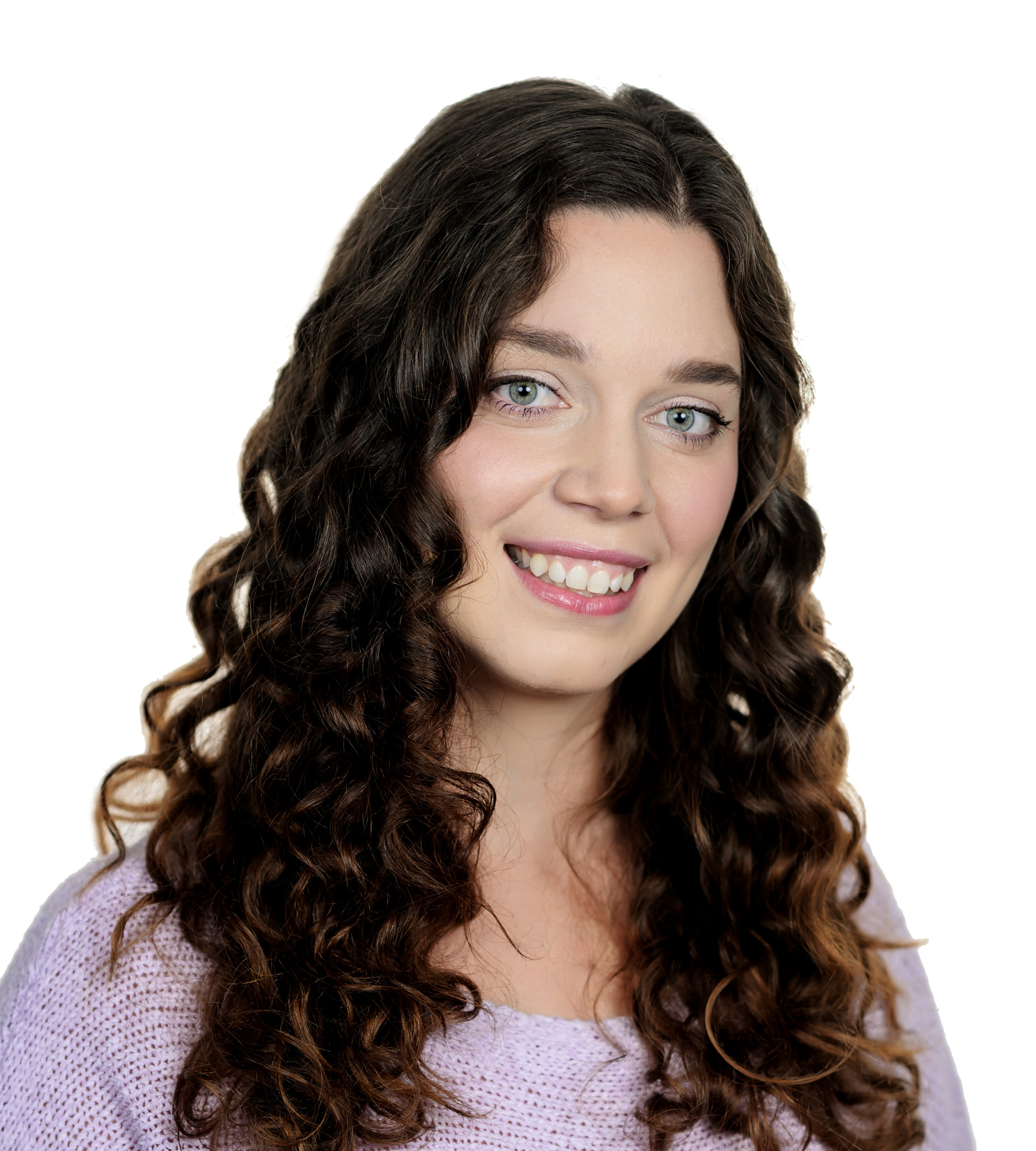 Portrait of a smiling woman with long, dark curly hair wearing a lavender sweater, against a white background
